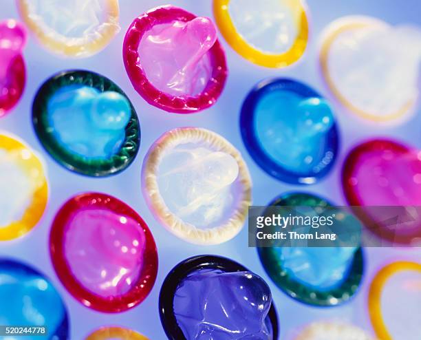 condoms in variety of colors - condom stock pictures, royalty-free photos & images