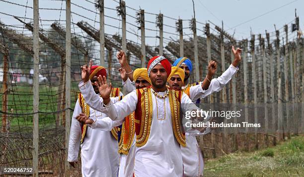 Artists perform the 'Bhangra', a punjabi folk dance, near India-Pakistan International border fence on the occasion of the Baisakhi festival in...