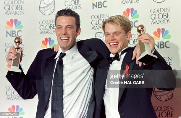 Actor Matt Damon and co-writer Ben Affleck pose with their Golden Globe award for Best Screenplay for "Good Will Hunting" at the 55th Annual Golden...