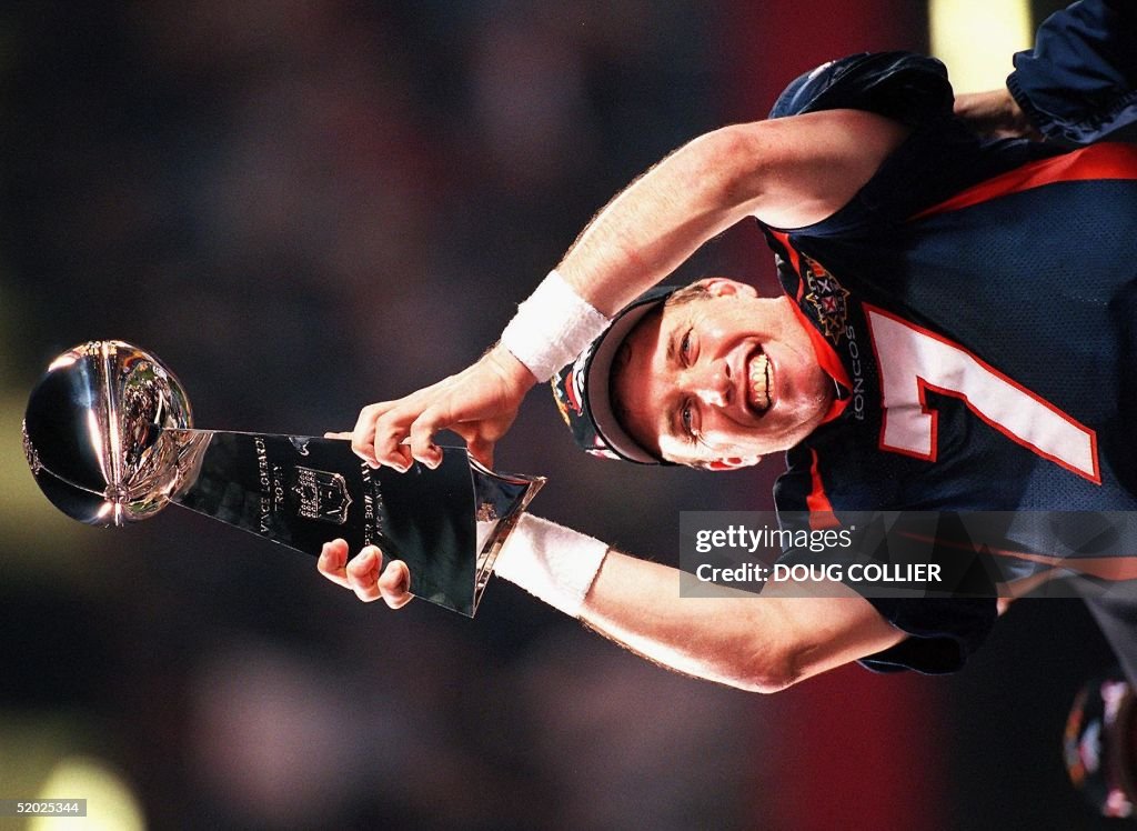 Denver Broncos quarterback John Elway holds the Vi