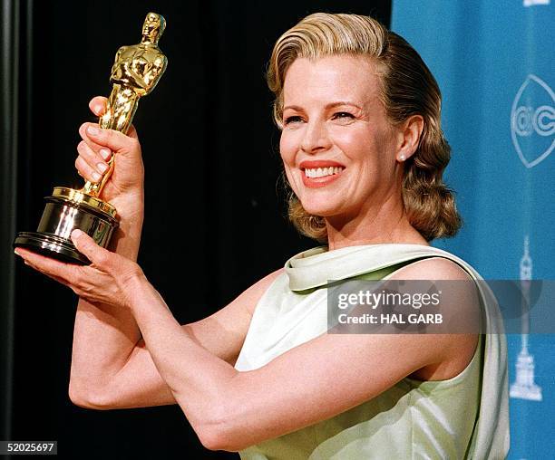 Actress Kim Basinger holds up her Oscar for Best Supporting Actress for her role in "L.A. Confidential" during the 70th Annual Academy Awards 23...