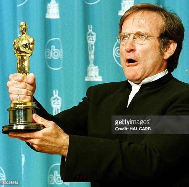 Actor Robin Williams holds the Oscar he won for Best Supporting Actor for his role in "Good Will Hunting" during the 70th Annual Academy Awards 23...