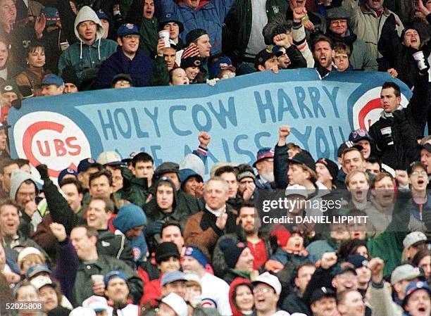 Chicago Cubs' fans hold a sign and cheer in memory of the late baseball announcer Harry Caray during the seventh inning stretch at Wrigley Field 03...