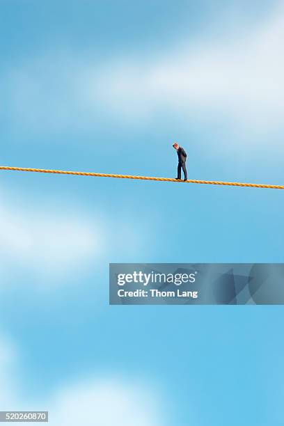 tightrope walking businessman - hochseil stock-fotos und bilder