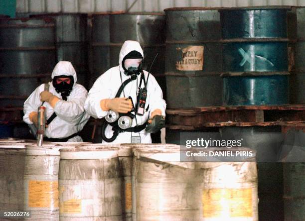 French experts in biological and chemical weapons check levels of radio activity as they inspect some 1,118 metal filled with toxic waste in a...