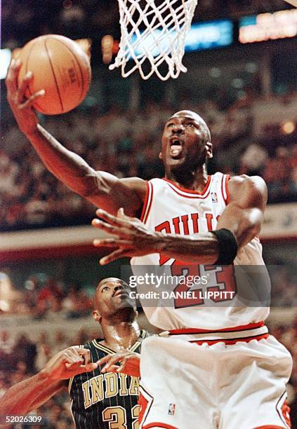 Michael Jordan of the Chicago Bulls drives to the basket past Dale Davis of the Indiana Pacers 17 May during the second half of game one of their NBA...