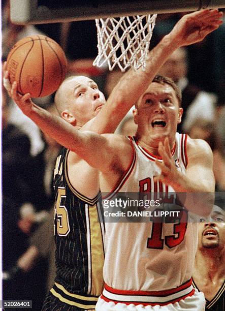 Luc Longley of the Chicago Bulls beats Rik Smits of the Indiana Pacers to the basket 27 May during the first half of game five of their NBA Eastern...