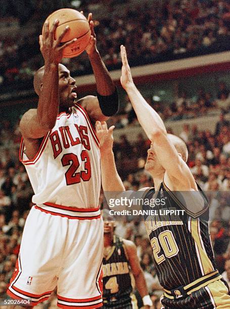 Michael Jordan of the Chicago Bulls drives to the basket past Fred Hoiberg of the Indiana Pacers 27 May during the second half of game five of their...
