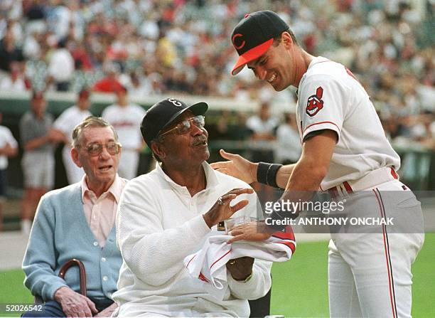 Cleveland Indians' short stop Omar Vizquel presents a signed 1998 Cleveland Indians team ball and jersey to 1948 Indians' outfielder Larry Doby...