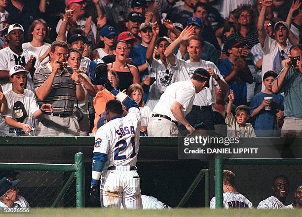 Chicago Cubs Sammy Sosa tips his cap to the fans after hitting his second home run of the night against the Philadelphia Phillies at Wrigley Field in...