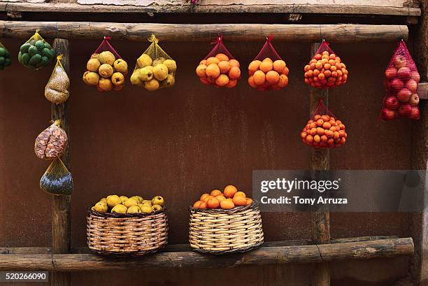 fruits hanging in baskets for sale - puesto de mercado agrícola fotografías e imágenes de stock