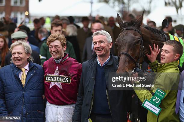 Jockey David Mullins poses in the winner's enclosure alongside trainer Mouse Morris and owner Michael O'Leary of Rule The World, winner of the...