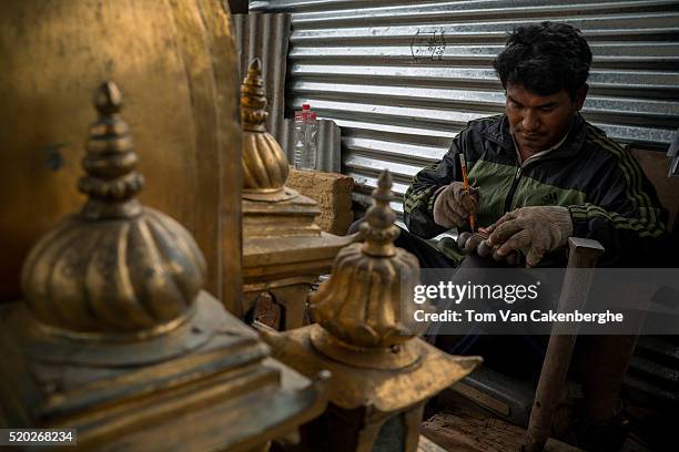 Babu Ratna Maharjan restores the gold-plated pinnacle of the minor Taleju temple tower of Patan Durbar, or Patan Palace, that sustained major damage...