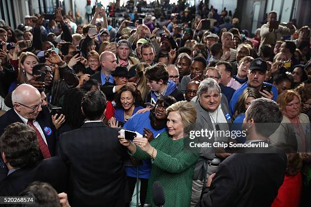Democratic presidential candidate Hillary Clinton takes a selfie with a supporter during a campaign rally at City Garage April 10, 2016 in Baltimore,...