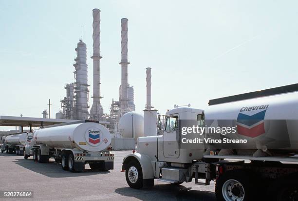 chevron oil trucks at refinery - chevron corporation stock-fotos und bilder