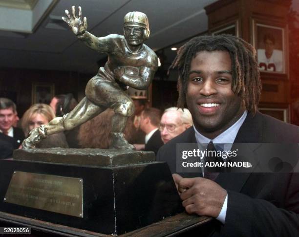 Texas tailback Ricky Williams, winner of the 1998 Heisman trophy, poses with US college football's highest honor 12 December at the Downtown Athletic...