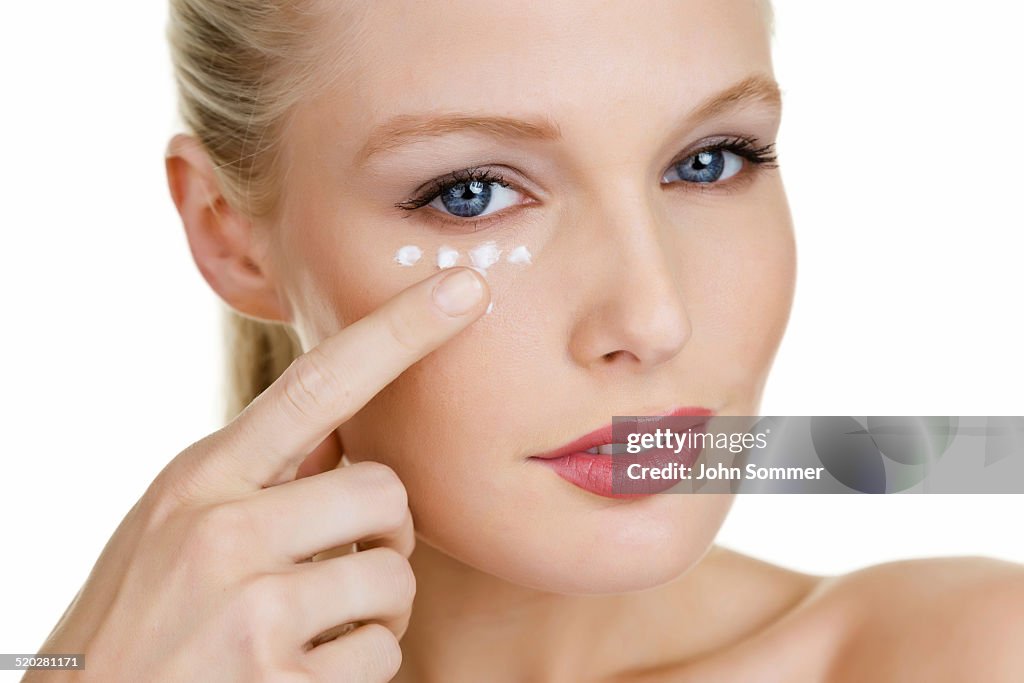 Beautiful woman moisturizing her skin