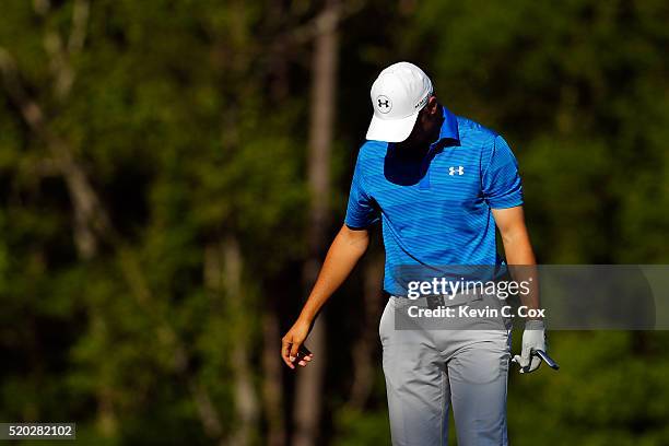 Jordan Spieth of the United States reacts after hitting his tee shot into the water on the 12th hole during the final round of the 2016 Masters...