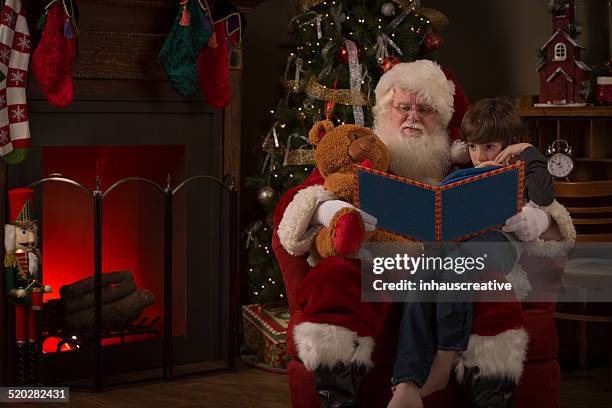 real santa claus lesen eine geschichte für ein junge - roman numeral stock-fotos und bilder