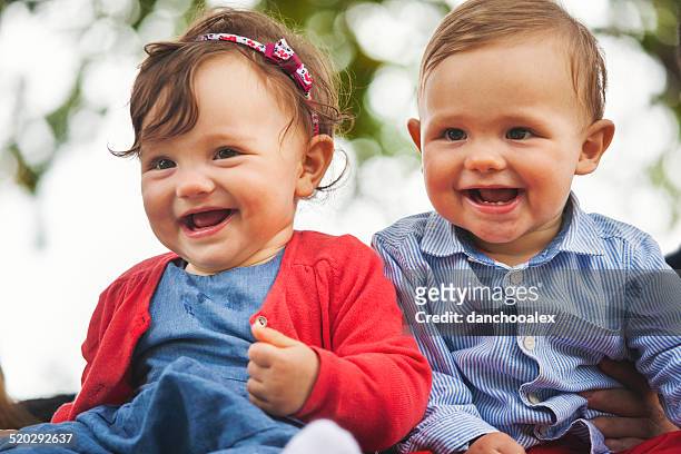 twin baby lächeln für die kamera - twins boys stock-fotos und bilder