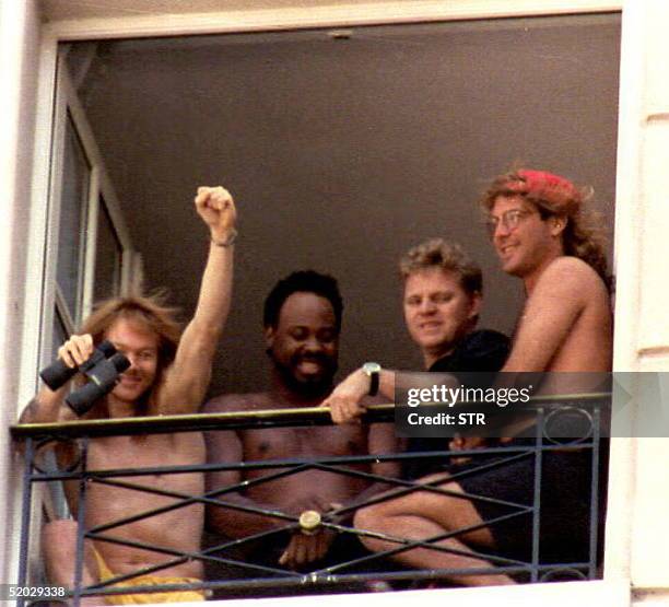 Axl Rose , leader of the rock group Guns N' Roses greets supporters 04 Dec from his hotel window together with other musicians. The group will...