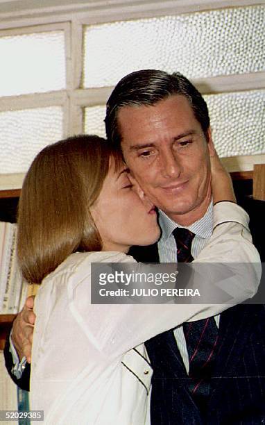 Former Brazilian President Fernando Collor de Mello gets a kiss 30 December 1992 from his wife, Rosane, at the end of a press conference where he...