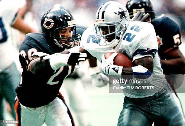 Runningback Emmitt Smith of the Dallas Cowboys runs past free safety Mark Carrier of the Chicago Bears 27 December 1992 in Texas, on his way to a...