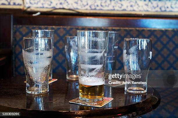 dirty beer glasses on a table - empty beer glass stock pictures, royalty-free photos & images