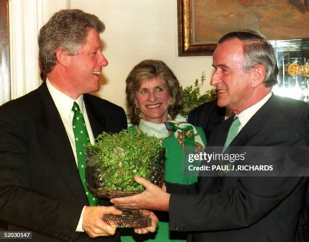 President Bill Clinton accepts a bowl of shamrocks in honor of St. Patrick's Day from Irish Prime Minister Albert Reynolds during a 17 March 1993...