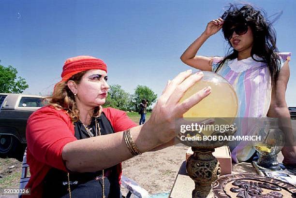 Self-proclaimed psychic Zena Marrs of Waco uses her crystal ball to look into the future of Margie Aleman 10 April 1993 at her roadside stand on a...