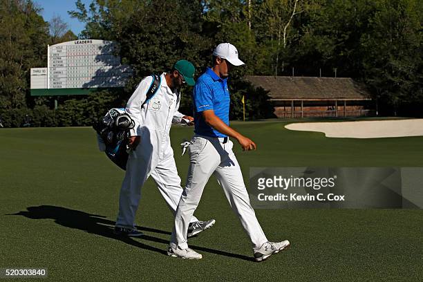 Jordan Spieth of the United States and caddie Michael Greller walk from the 12th tee during the final round of the 2016 Masters Tournament at Augusta...