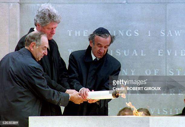 President Bill Clinton lights the eternal flame at the United States Holocaust Memorial Museum 22 April 1993 with help from Memorial Council Chairman...