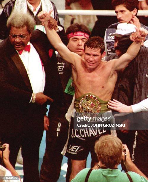Boxing promoter Don King helps raise WBC super-lightweight boxing champion Julio Cesar Chavez's hands in victory after Chavez defeated challenger...