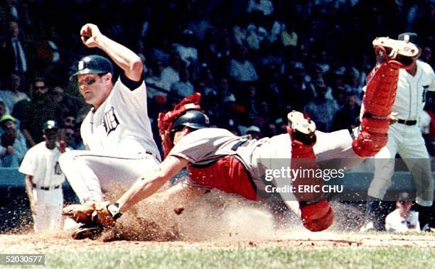 Detroit Tigers' Kirk Gibson slides safely into home 26 May 1993 in Detroit as Boston Red Sox' catcher Bob Melvin tries to make the tag during the...