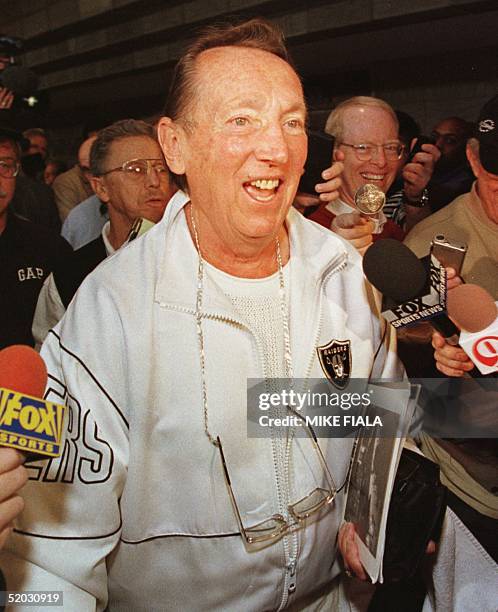 Owner of the Oakland Raiders Al Davis makes his way through a crowd of reporters during the 1999 NFL Annual Meeting 15 March, 1999 at the Biltmore...