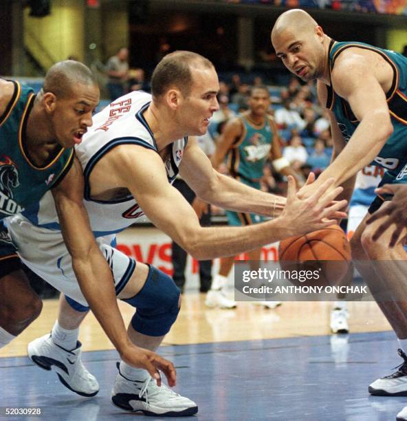 Cleveland Cavaliers' Danny Ferry scrambles for control of a loose ball with Detroit Piston's Jerome Williams and Bison Dele after a rebound attempt...