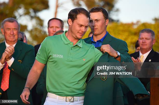 Golfer Jordan Spieth presents the Green Jacket to England's Danny Willett at the end of the 80th Masters Golf Tournament at the Augusta National Golf...