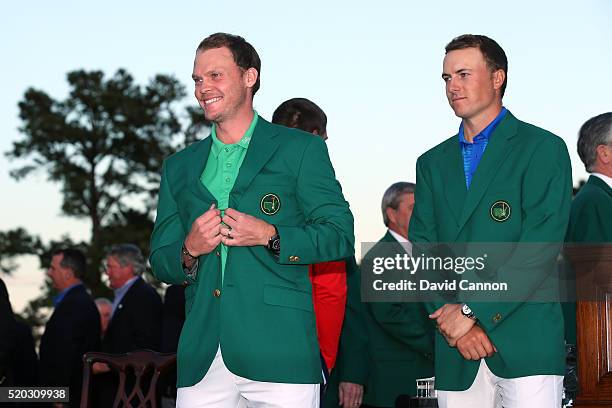 Jordan Spieth of the United States presents Danny Willett of England with the green jacket after Willett won the final round of the 2016 Masters...