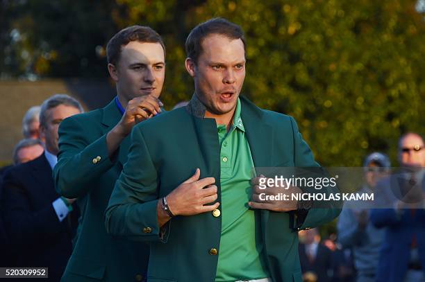 Golfer Jordan Spieth presents the Green Jacket to England's Danny Willett at the end of the 80th Masters Golf Tournament at the Augusta National Golf...