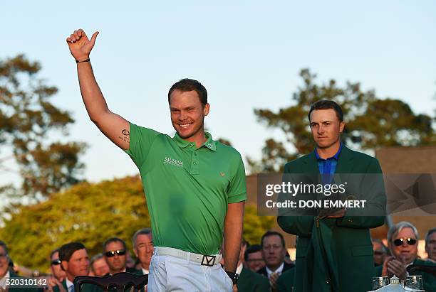 Golfer Jordan Spieth looks on as England's Danny Willett waves during presentation ceremony at the end of the 80th Masters Golf Tournament at the...