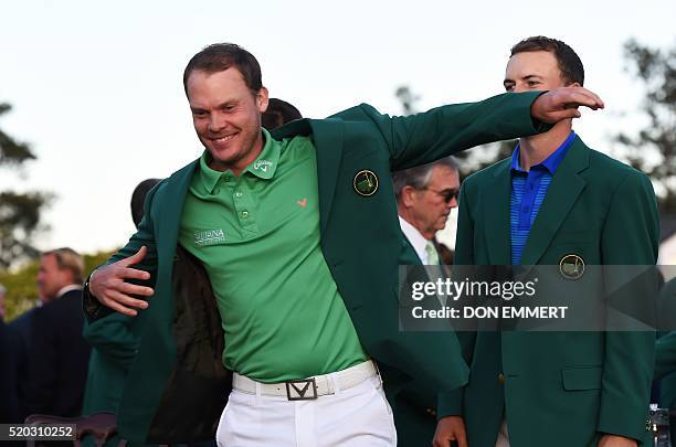 Golfer Jordan Spieth presents the Green Jacket to England's Danny Willett at the end of the 80th Masters Golf Tournament at the Augusta National Golf...