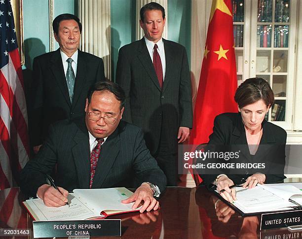 Chinese Prime Minister Zhu Rongji and US Vice President Al Gore stand at the signing of an environmental agreement by Xie Zhenhhua , China's minister...