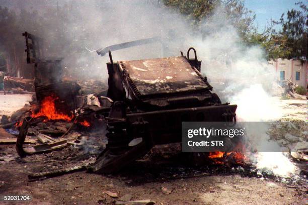 The wreckage of a U.S. Military vehicle burns 03 October 1993 after it was destroyed by a remote-controlled bomb, injuring three U.S. Marines and...