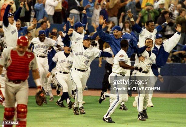 Philadelphia Phillies catcher Darren Daulton walks off the field as members of the Toronto Blue Jays run out onto the field 23 October 1993 after Joe...