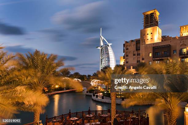 burj al arab hotel behind madinat jumeirah resort - hotel madinat jumeirah stockfoto's en -beelden