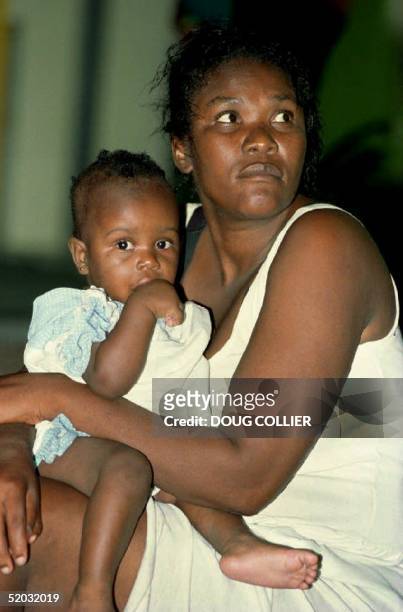 Haitian woman holds a child early 15 November 1993 after she was found wandering on Virginia Key, just south of Miami Beach. At least ten adults and...