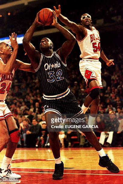 Orlando Magic center Shaquille O'Neal goes up for a shot as Chicago Bulls Horace Grant lunges to attempt a block in Chicago, IL, 25 December 1994 as...