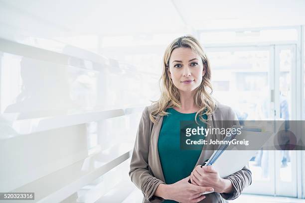 mid adult businesswoman with paperwork, portrait - will files stock pictures, royalty-free photos & images