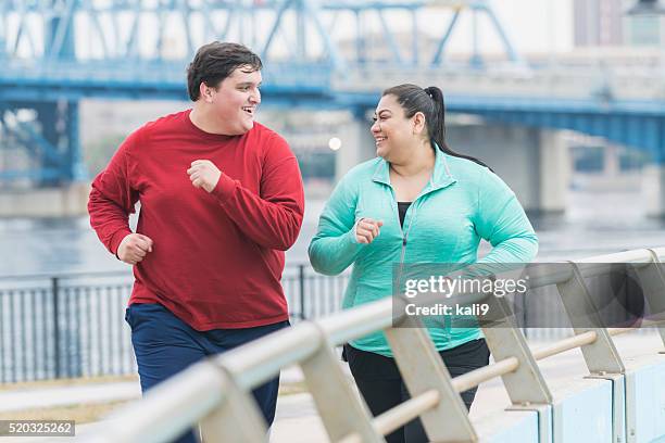 overweight man and woman jogging in the city - overweight exercising stock pictures, royalty-free photos & images