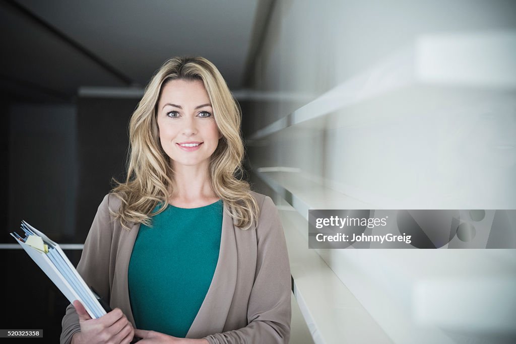 Mid adult businesswoman holding file at work